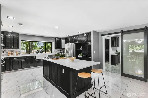 an open kitchen with stainless steel appliances granite countertop a stove and a sink
