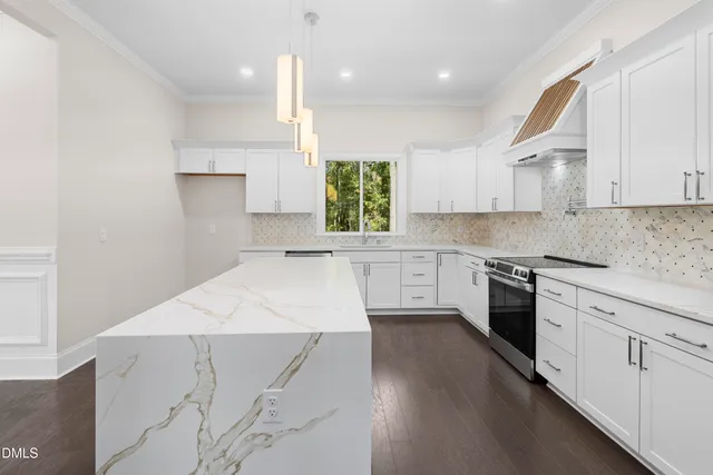 a kitchen with granite countertop white cabinets and stainless steel appliances
