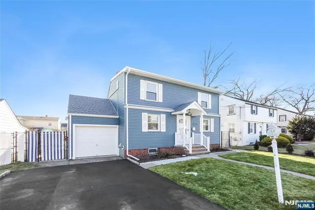 a front view of a house with a garden and yard