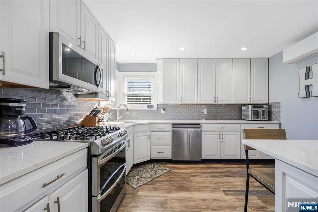 23-26 Berkshire Road Fair Lawn, NJ 07410 - Photo 14 of 36 a kitchen with stainless steel appliances granite countertop a stove top oven a sink a counter space and cabinets