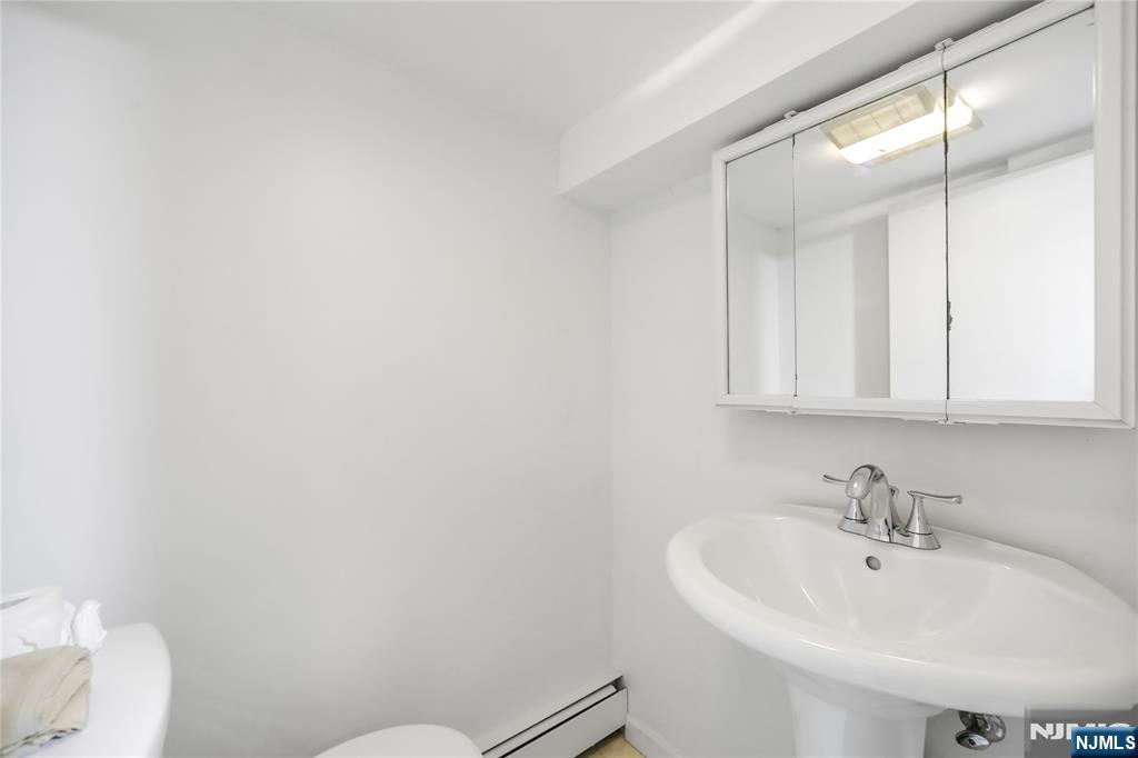 23-26 Berkshire Road Fair Lawn, NJ 07410 - Photo 30 of 36 a bathroom with a sink a toilet and mirror
