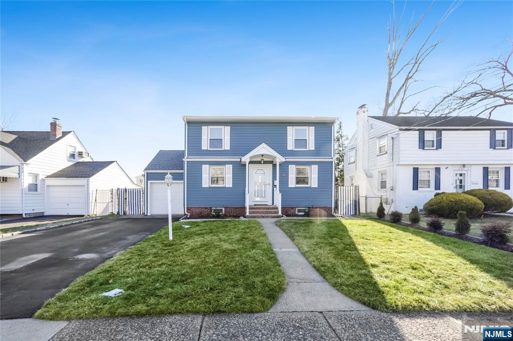 23-26 Berkshire Road Fair Lawn, NJ 07410 - Photo 4 of 36 a view of a big yard in front of a brick house with large windows