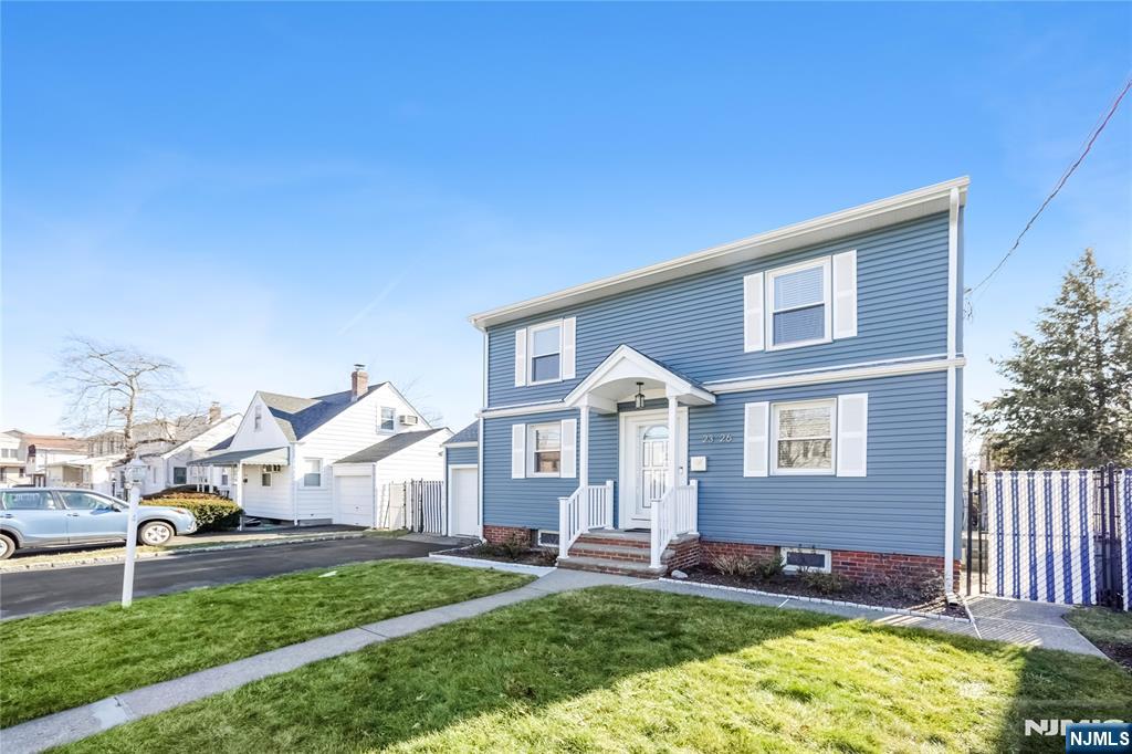 23-26 Berkshire Road Fair Lawn, NJ 07410 - Photo 5 of 36 a front view of a house with a yard and garage