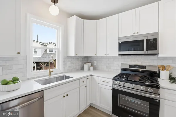 a kitchen with stainless steel appliances a stove a sink and a microwave
