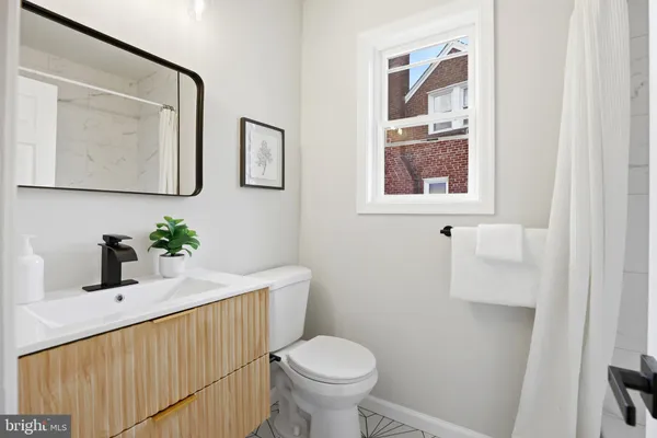 a bathroom with a toilet a sink and mirror