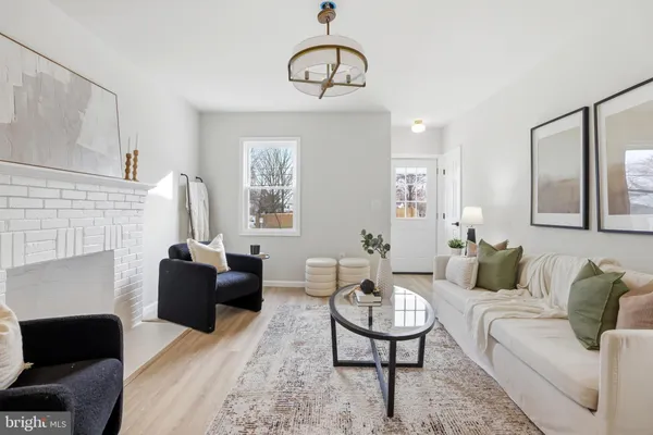 a living room with furniture a fireplace and a chandelier