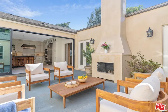 a living room with furniture a fireplace and a potted plant