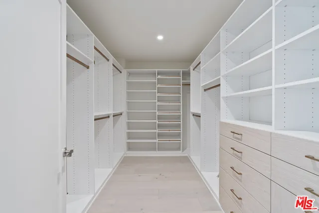 a view of walk in closet with empty racks