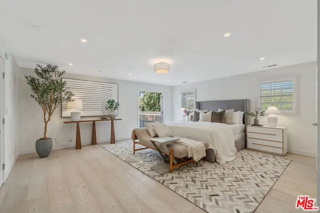 a bedroom with a bed and a potted plant