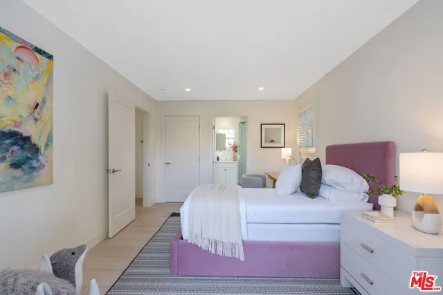 a bedroom with a bed and a lamp on dresser