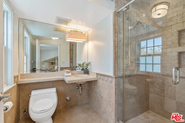 a bathroom with a toilet a sink and mirror