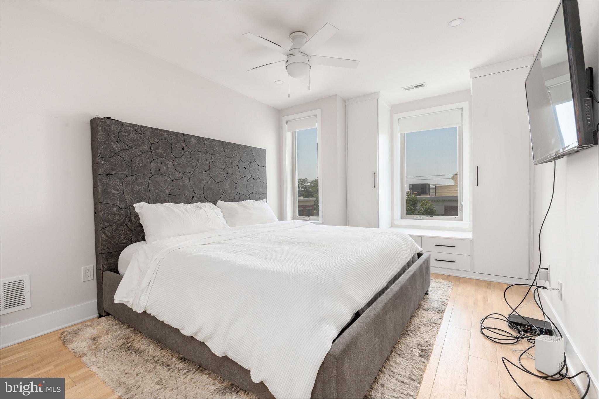 1733 Carpenter Street, Unit D Philadelphia, PA 19146 - Photo 16 of 37 a spacious bedroom with a bed and a chandelier