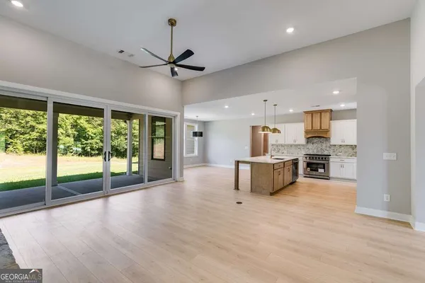 a view of kitchen with kitchen island wooden floor center island and stainless steel appliances