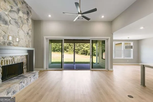 an empty room with floor to ceiling windows and fireplace
