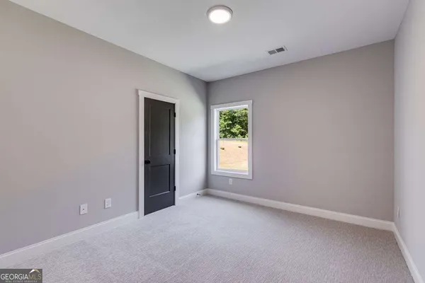 an empty room with a window and a bathroom