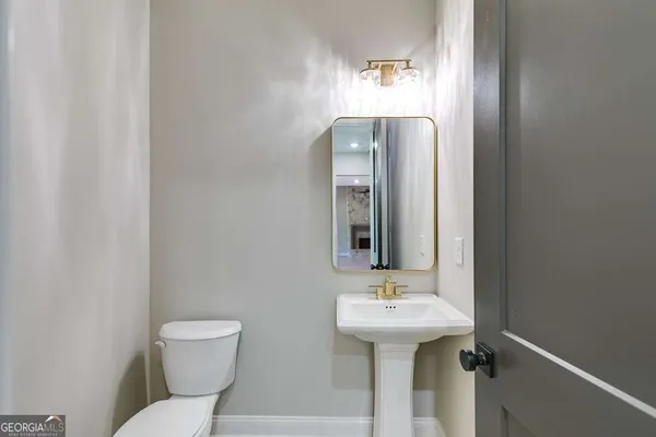 a bathroom with a sink toilet and mirror