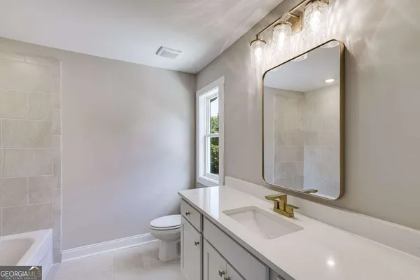 a bathroom with a double vanity sink toilet and mirror