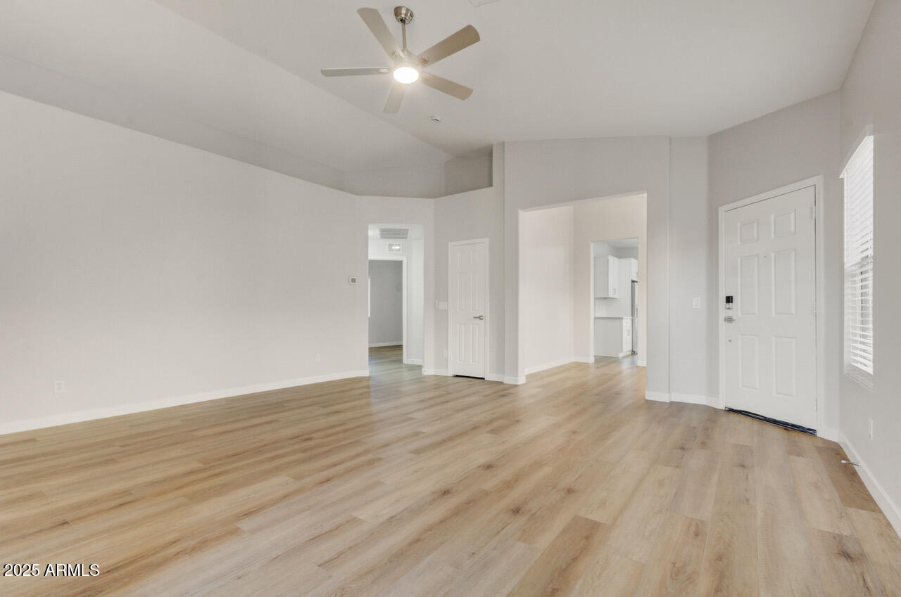 13431 West Evans Drive Surprise, AZ 85379 - Photo 11 of 37 an empty room with wooden floor and windows