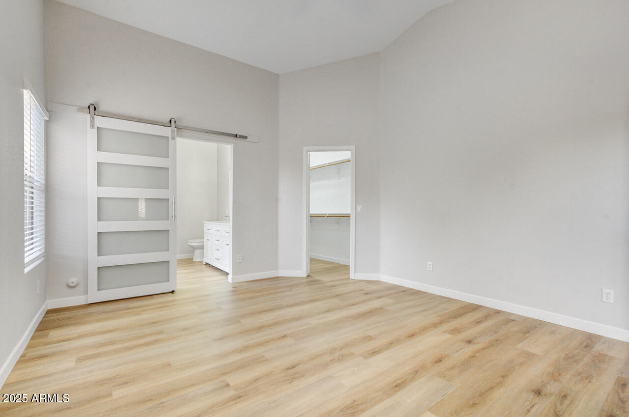 13431 West Evans Drive Surprise, AZ 85379 - Photo 15 of 37 a view of an empty room with a window and wooden floor