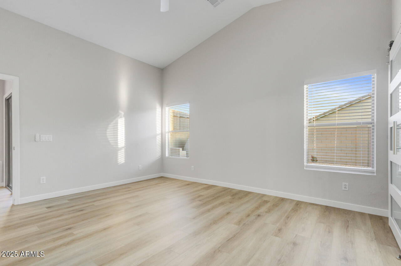 13431 West Evans Drive Surprise, AZ 85379 - Photo 17 of 37 an empty room with wooden floor and windows