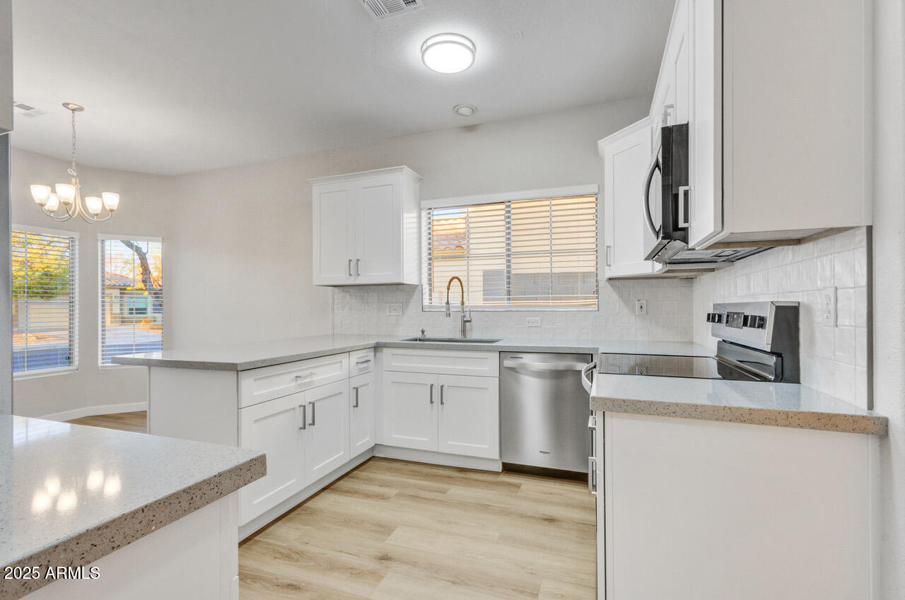13431 West Evans Drive Surprise, AZ 85379 - Photo 2 of 37 a kitchen with stainless steel appliances granite countertop a sink stove and cabinets