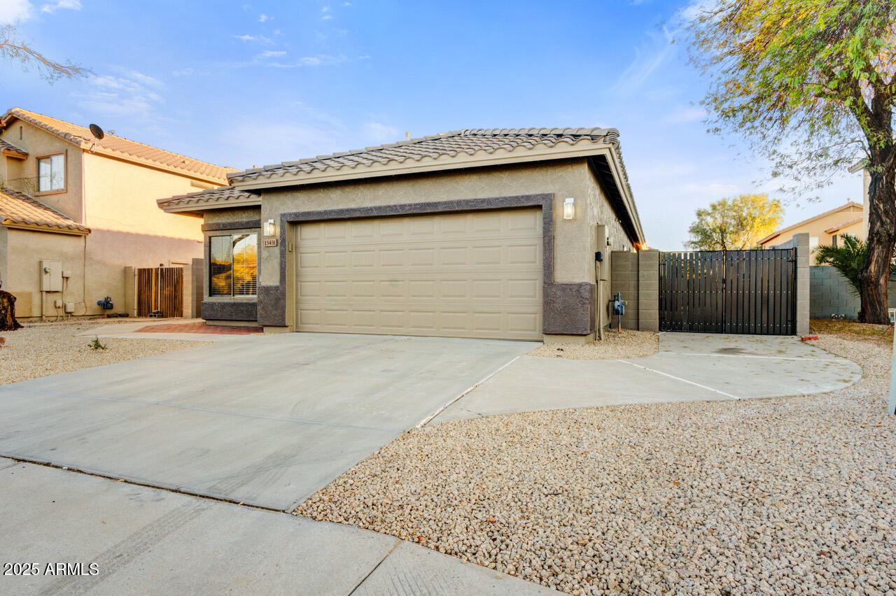 13431 West Evans Drive Surprise, AZ 85379 - Photo 35 of 37 a front view of a house with a yard and garage