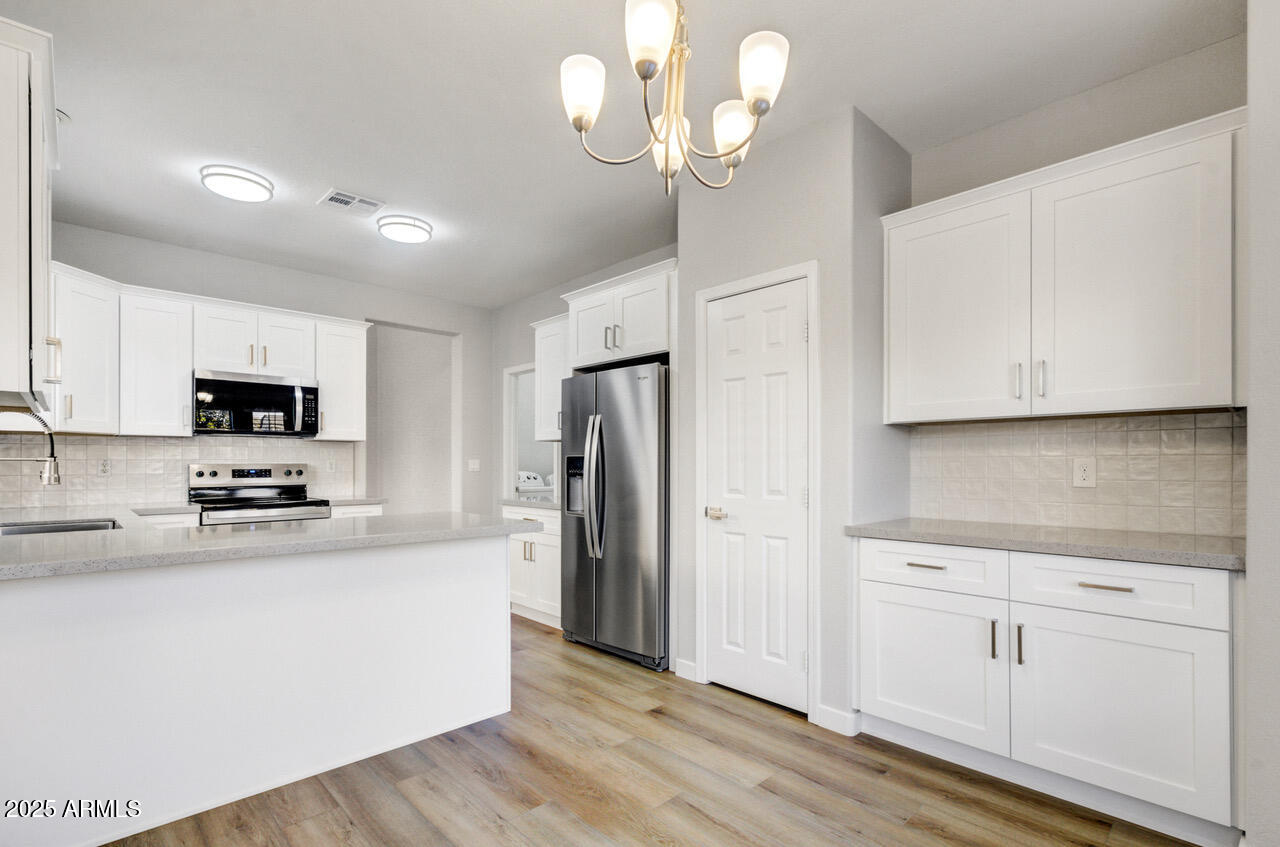 13431 West Evans Drive Surprise, AZ 85379 - Photo 5 of 37 a kitchen with stainless steel appliances a white stove top oven and refrigerator