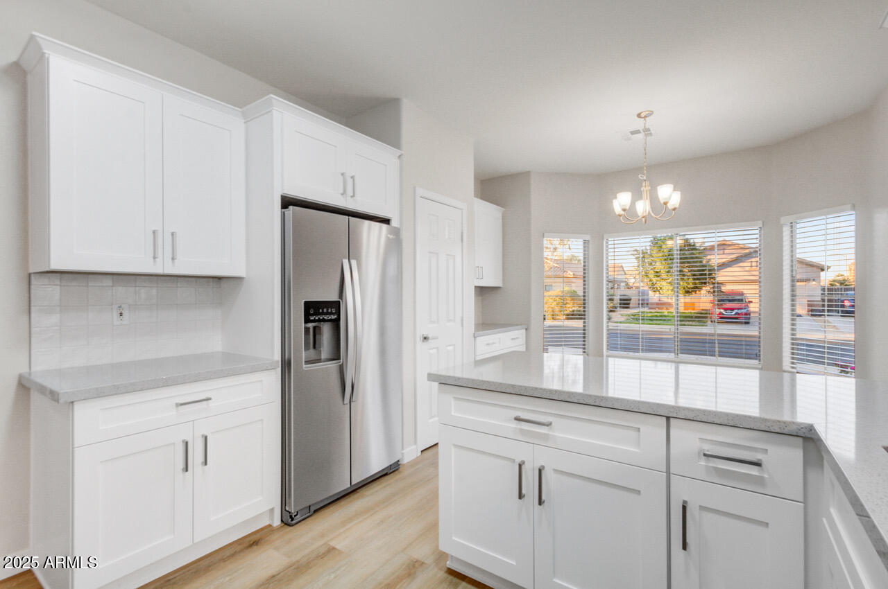 13431 West Evans Drive Surprise, AZ 85379 - Photo 7 of 37 a kitchen with white cabinets and refrigerator