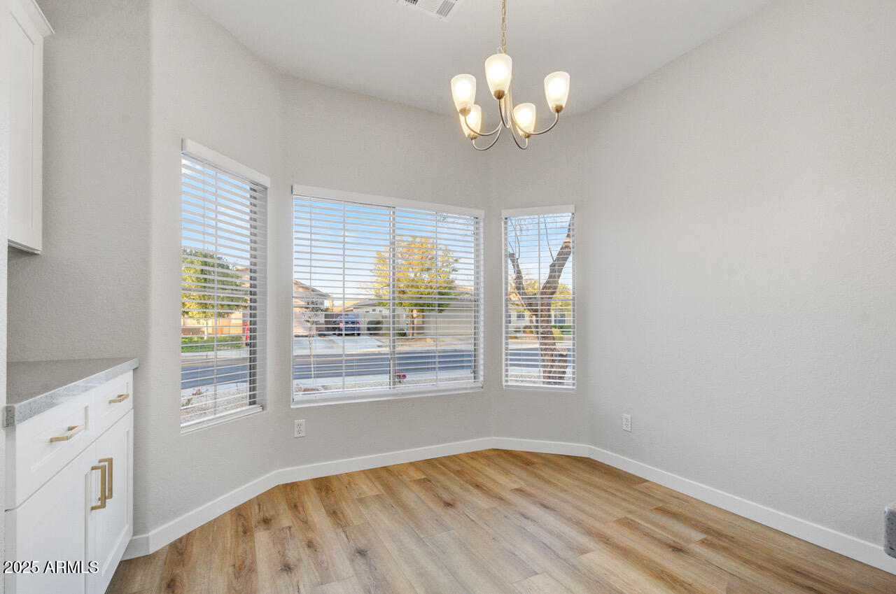 13431 West Evans Drive Surprise, AZ 85379 - Photo 8 of 37 a view of an empty room with a window and wooden floor
