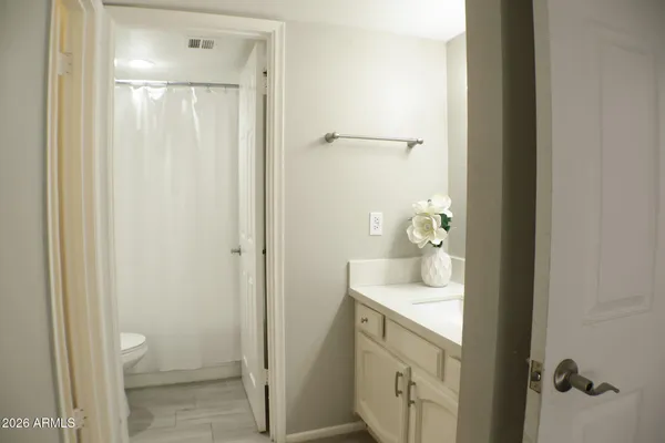 a bathroom with a granite countertop sink a toilet and shower