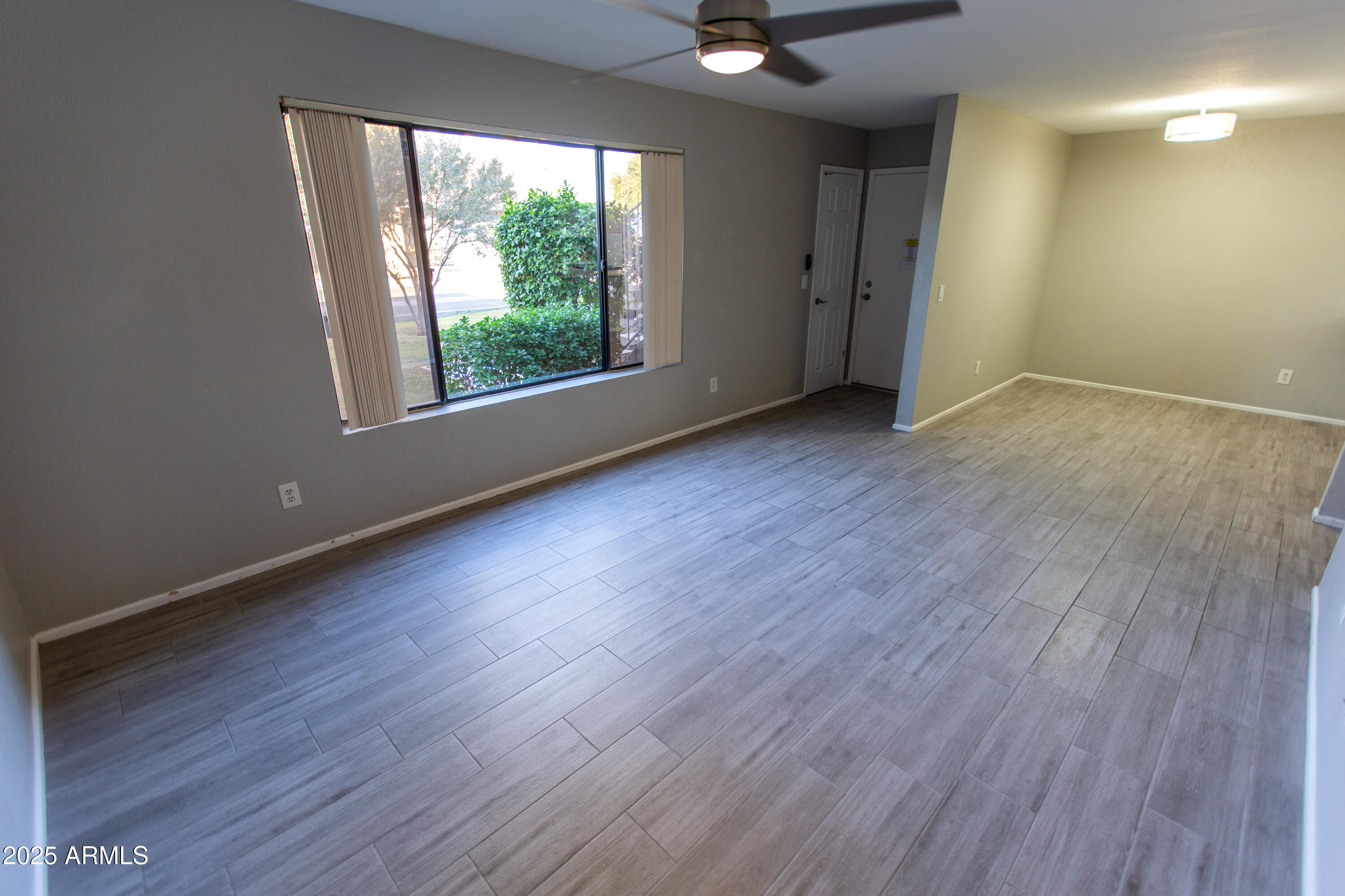 1402 East Guadalupe Road, Unit 153 Tempe, AZ 85283 - Photo 13 of 25 a view of an empty room with wooden floor and a window