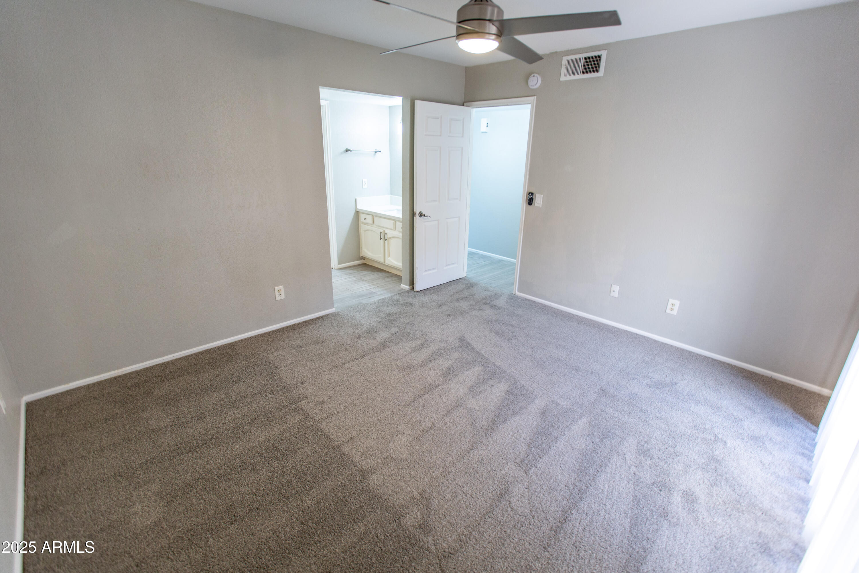 1402 East Guadalupe Road, Unit 153 Tempe, AZ 85283 - Photo 19 of 25 a view of an empty room with a chandelier fan