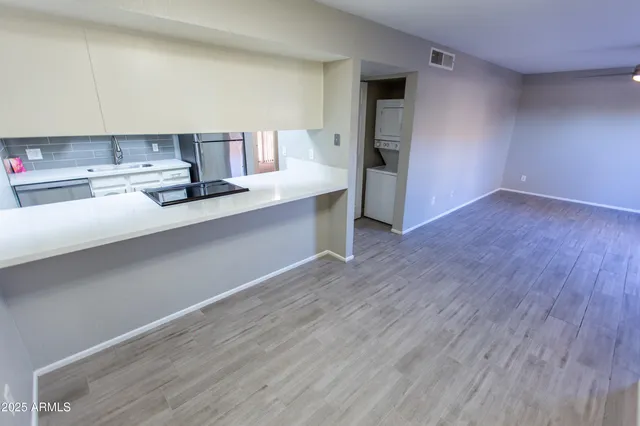 a kitchen with stainless steel appliances a sink cabinets and wooden floor