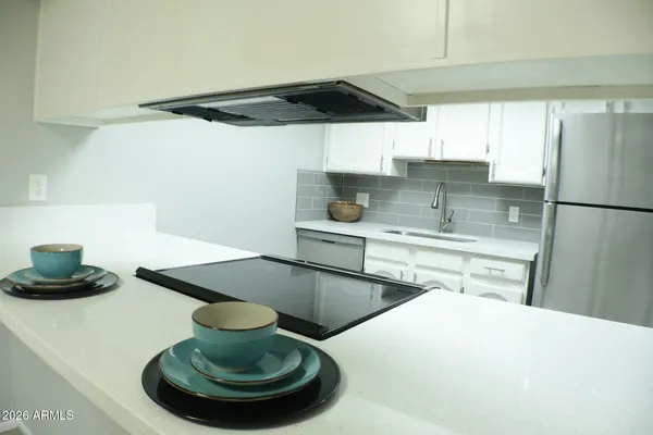 a kitchen with white cabinets and appliances