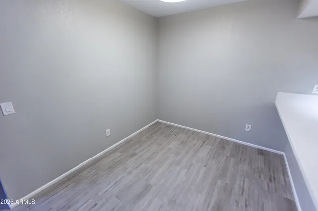 a view of an empty room with wooden floor