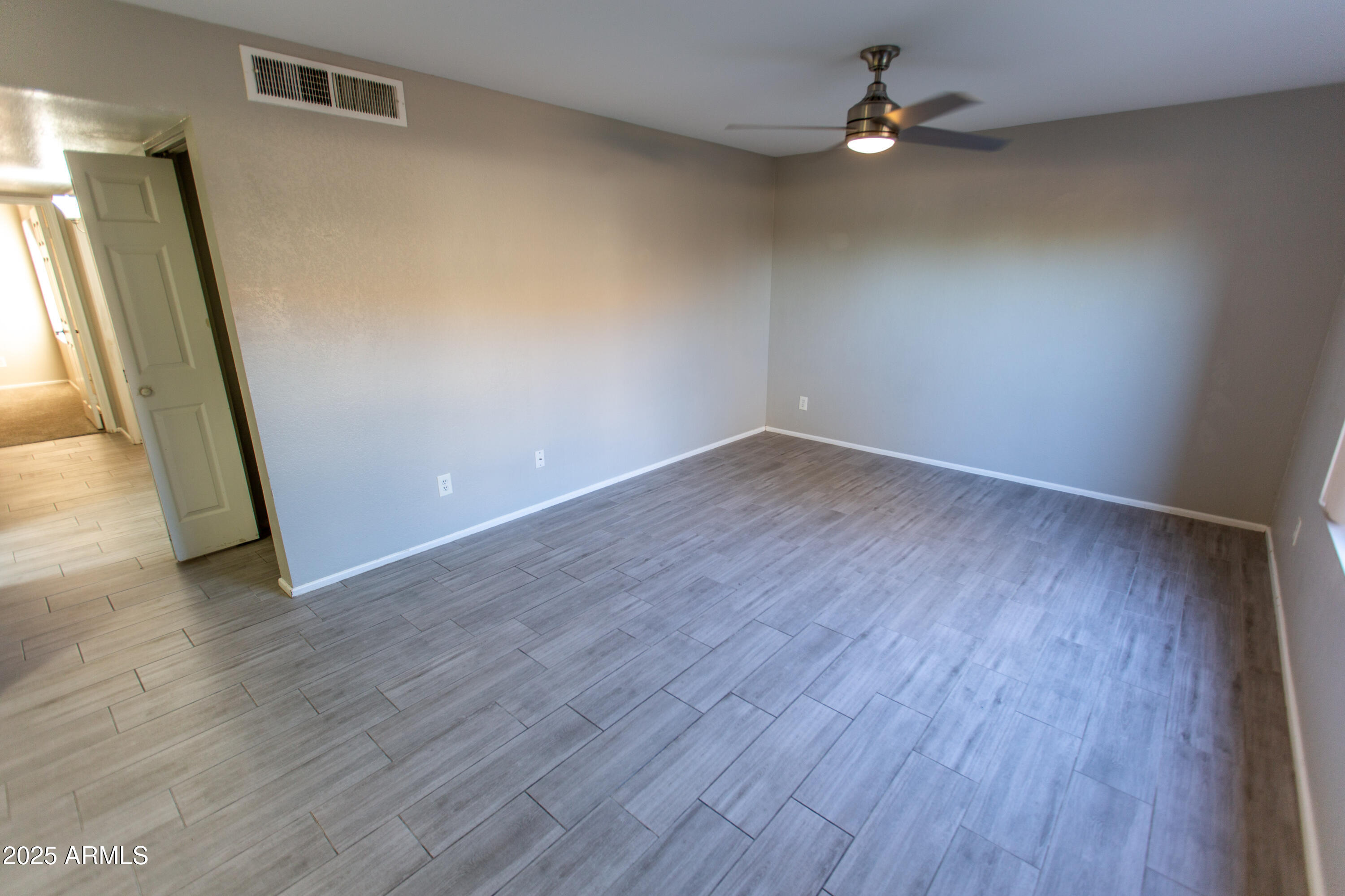 1402 East Guadalupe Road, Unit 153 Tempe, AZ 85283 - Photo 10 of 25 an empty room with wooden floor and windows