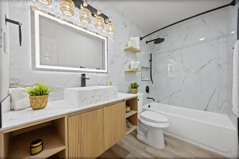 a bathroom with a sink a toilet and shower