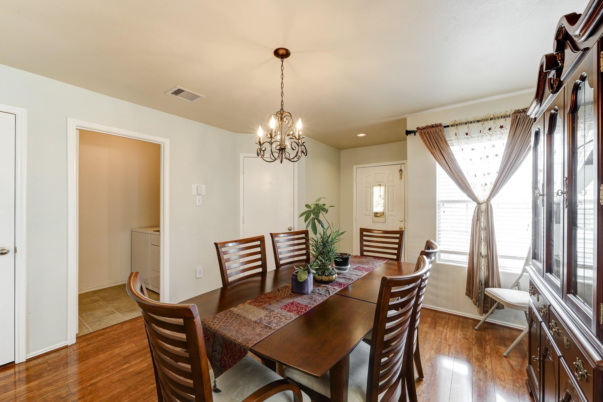 1934 Robcrest Way Missouri City, TX 77489 - Photo 5 of 24 a dining room with furniture a chandelier and wooden floor