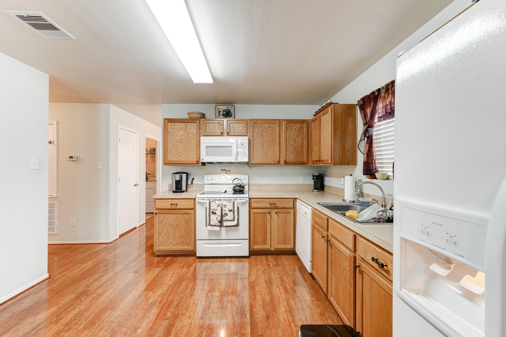 1934 Robcrest Way Missouri City, TX 77489 - Photo 7 of 24 a kitchen with stainless steel appliances granite countertop a stove top oven a refrigerator a sink and dishwasher with wooden floor