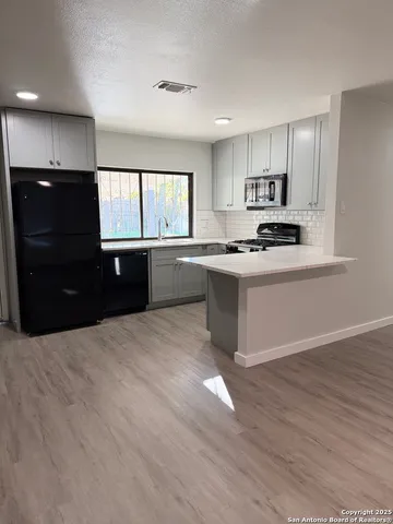 a kitchen with stainless steel appliances granite countertop a stove a sink and a refrigerator