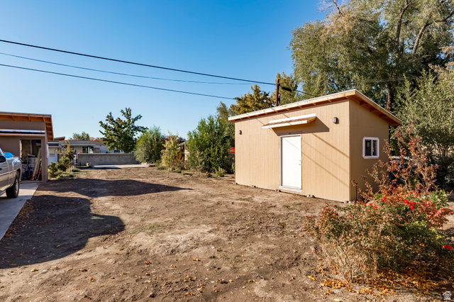4658 Box Elder Street Salt Lake City, UT 84107 - Photo 16 of 17 Freestanding storage shed with wood-finish siding, a pitched roof, and a white entry door