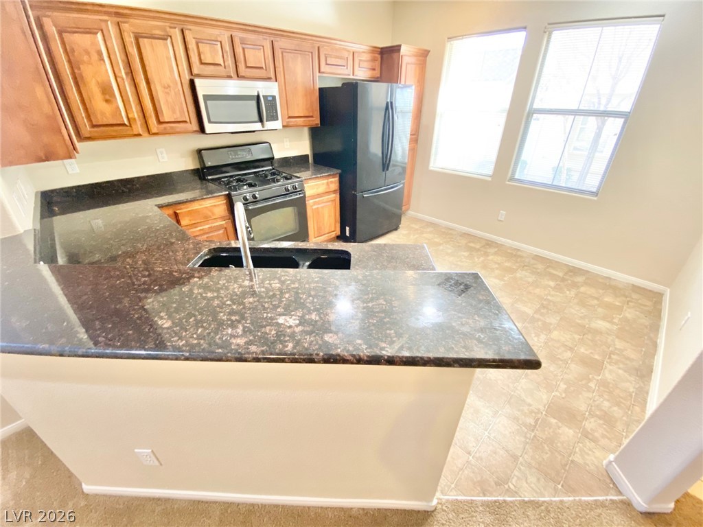 8569 Rhamus Court Las Vegas, NV 89149 - Photo 4 of 35 Culinary delights await in this modern kitchen with dark countertops and ample cabinetry.