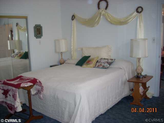 13824 Cross County Road Mineral, VA 23117 - Photo 3 of 12 a bedroom with a bed and a chandelier