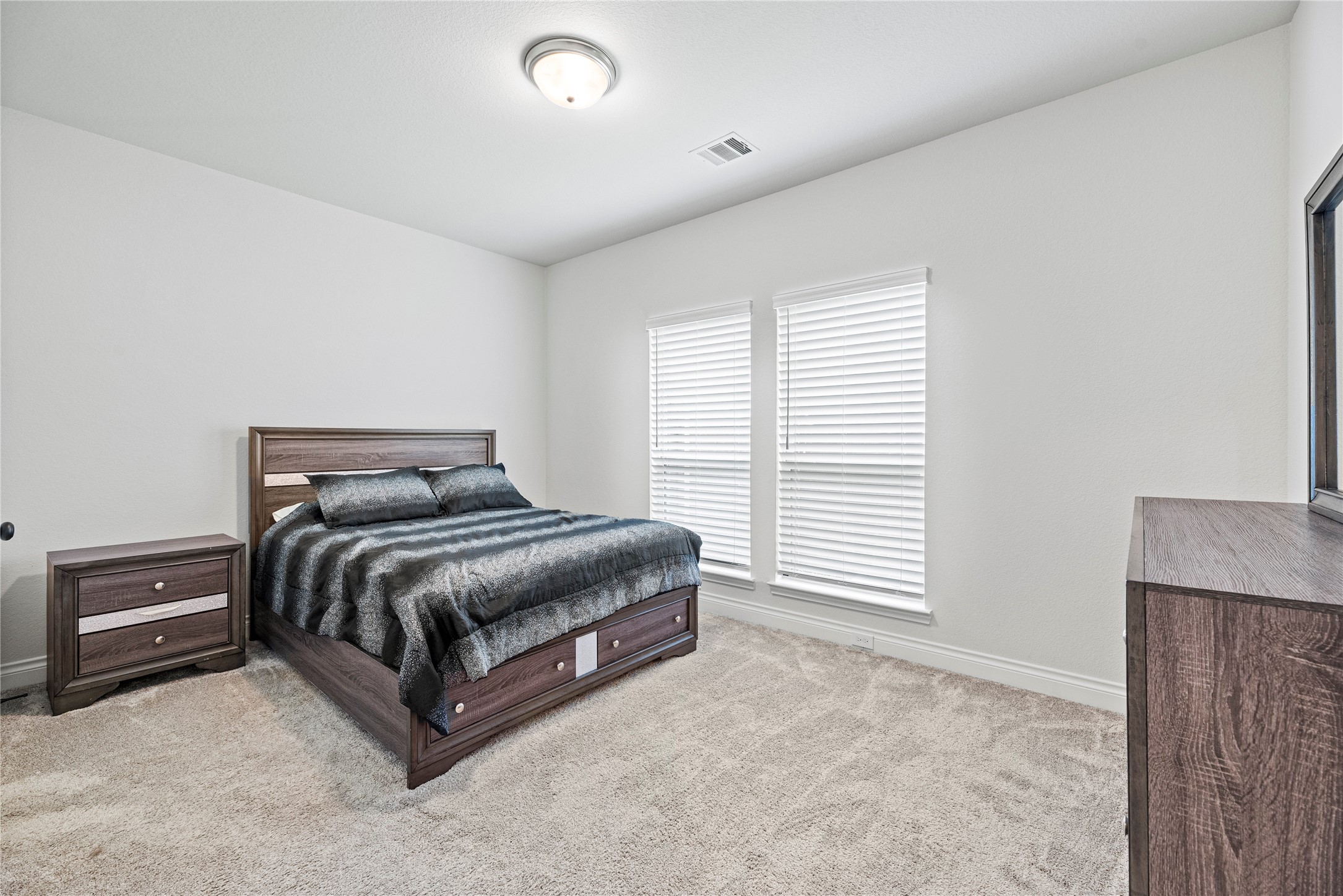 6938 Amberwing Way Katy, TX 77493 - Photo 18 of 38 a spacious bedroom with a bed and a cabinets