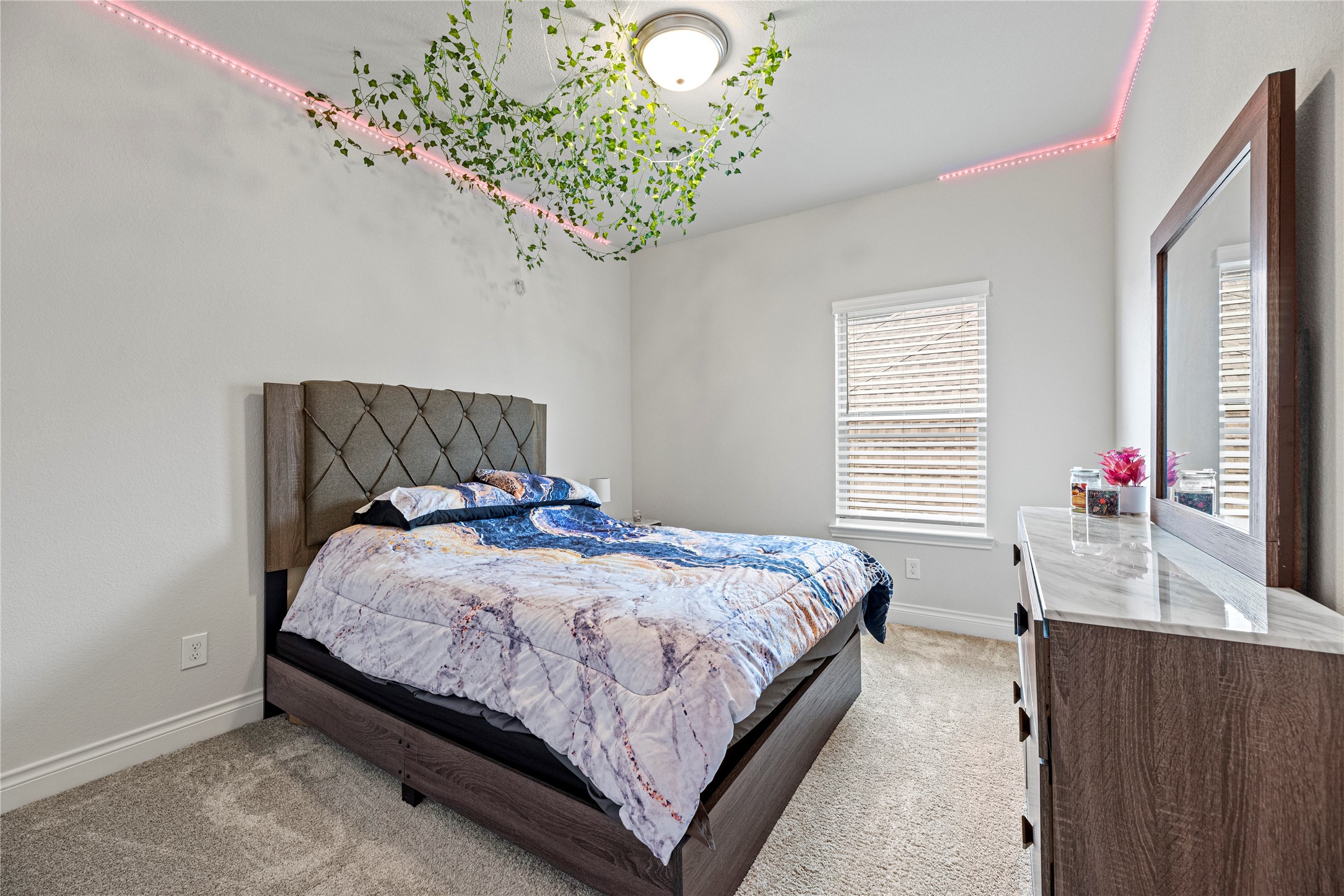 6938 Amberwing Way Katy, TX 77493 - Photo 20 of 38 a bedroom with a bed and a chandelier