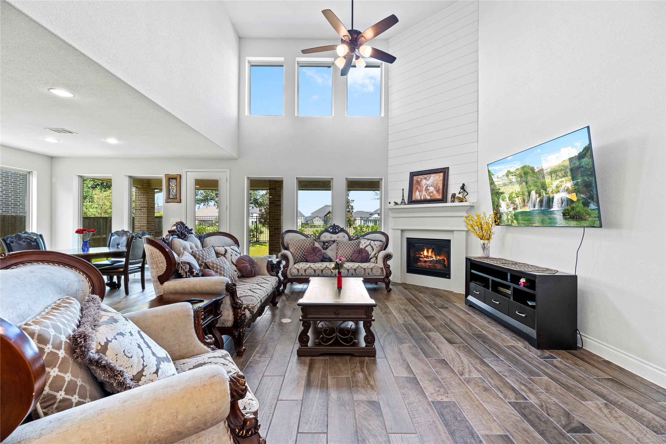 6938 Amberwing Way Katy, TX 77493 - Photo 3 of 38 a living room with furniture a fireplace a flat screen tv and paintings on the wall