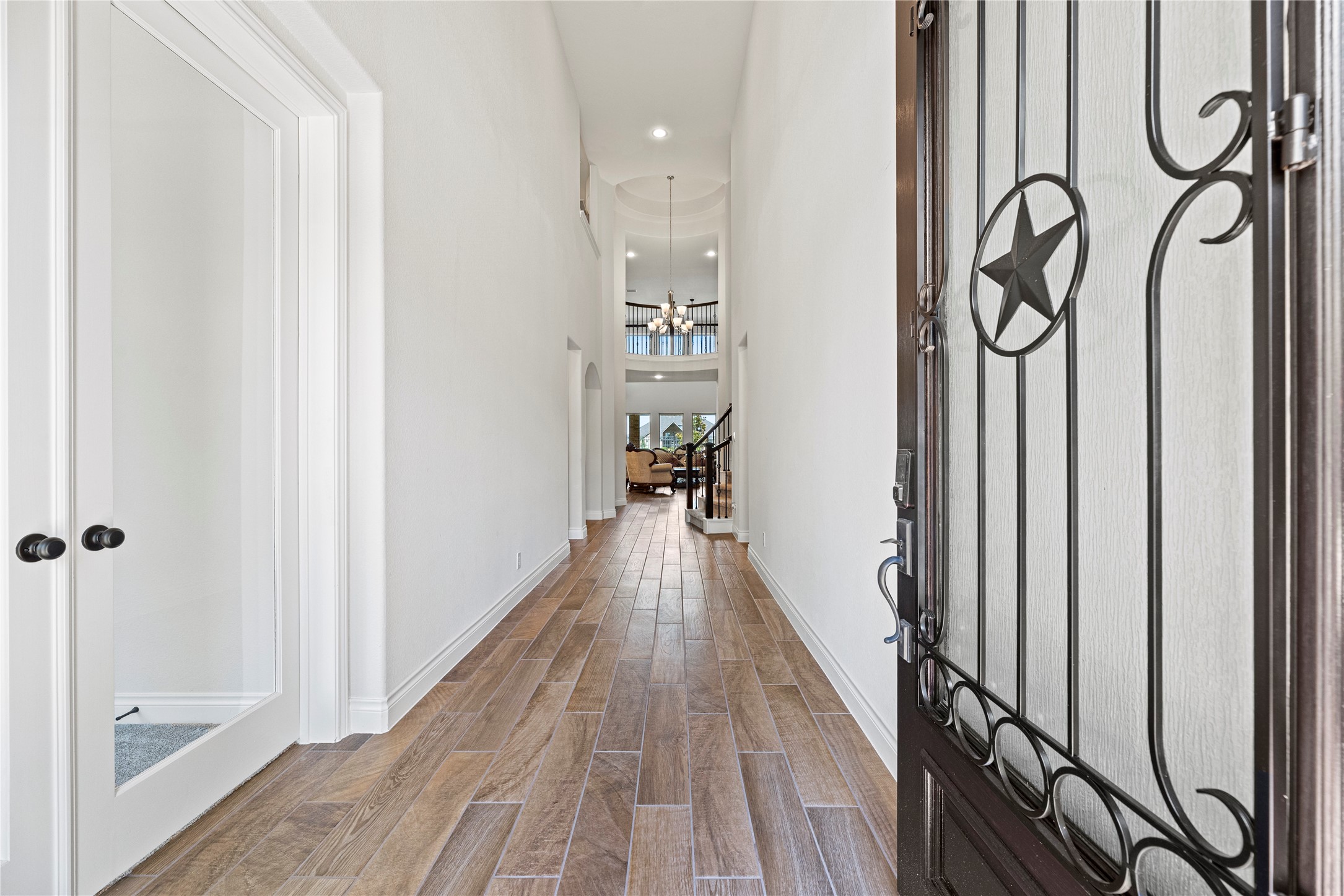 6938 Amberwing Way Katy, TX 77493 - Photo 6 of 38 a view of a hallway with wooden floor and staircase