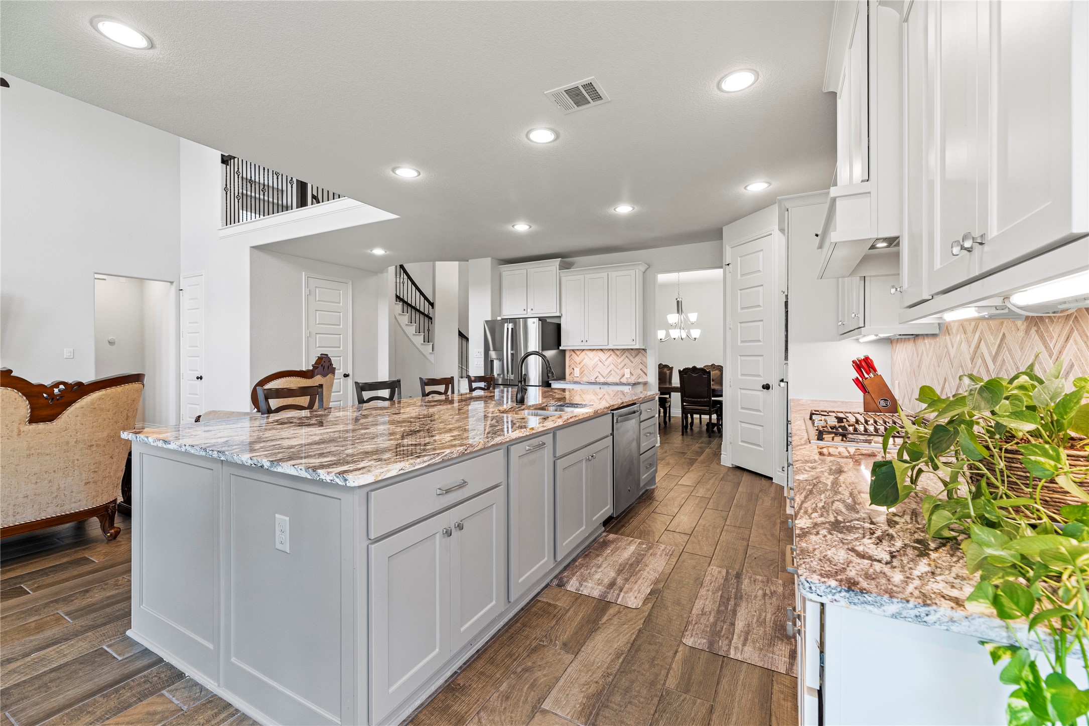 6938 Amberwing Way Katy, TX 77493 - Photo 10 of 38 a open kitchen with kitchen island granite countertop a sink and white cabinets