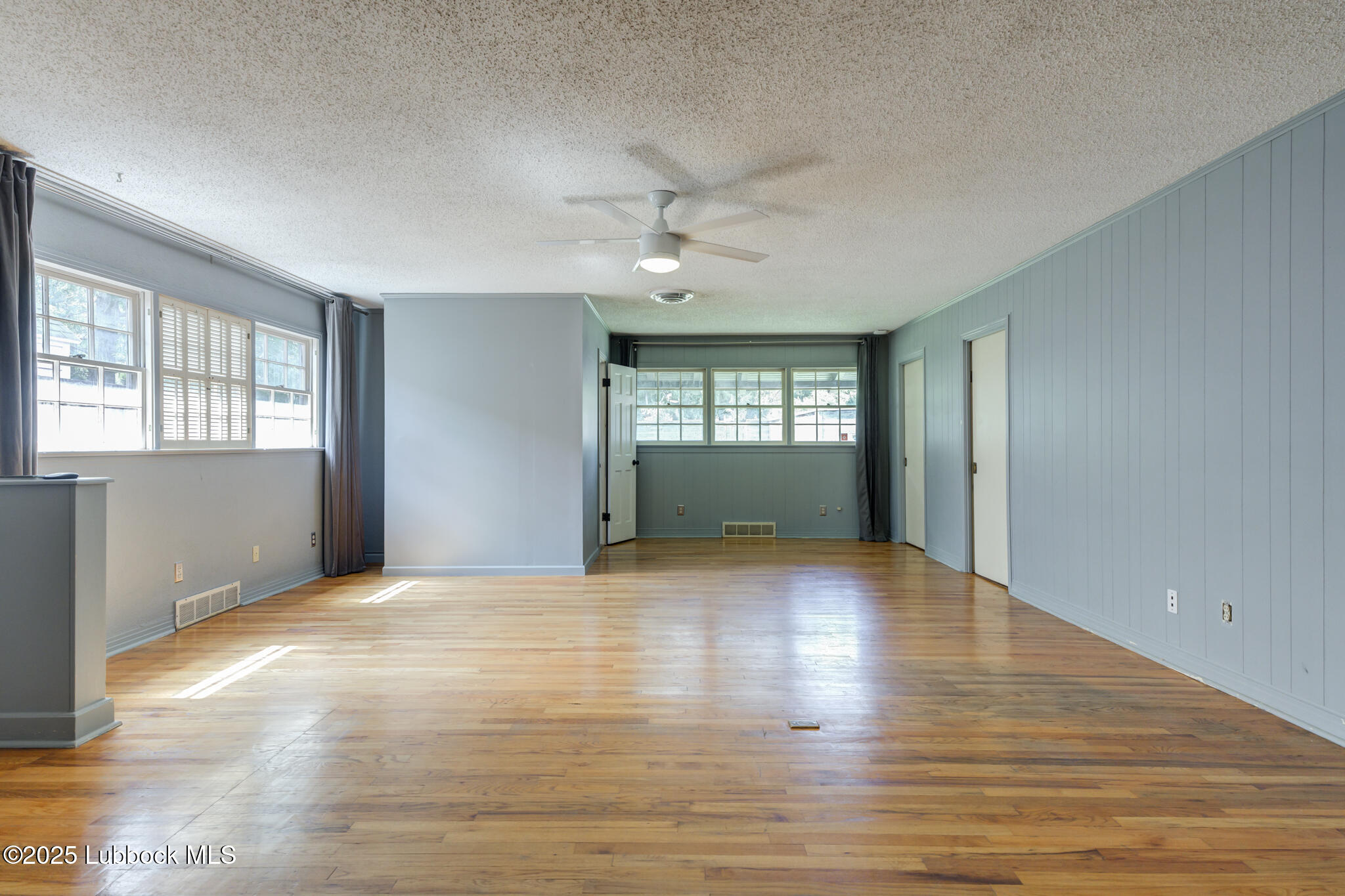 3309 22nd Street Lubbock, TX 79410 - Photo 19 of 37 an empty room with wooden floor and windows