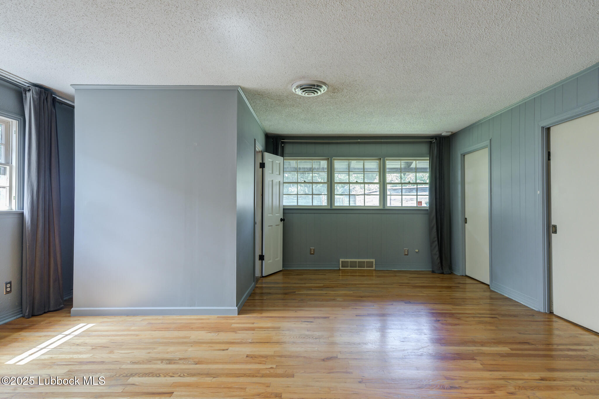3309 22nd Street Lubbock, TX 79410 - Photo 20 of 37 a view of an empty room with wooden floor and a window